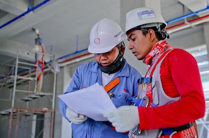 Two factory workers examining a document