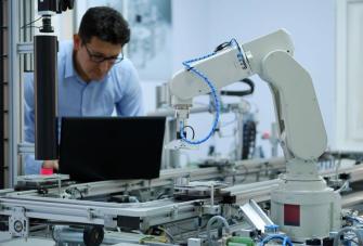  robotic arm which picks up product from automated car on production line